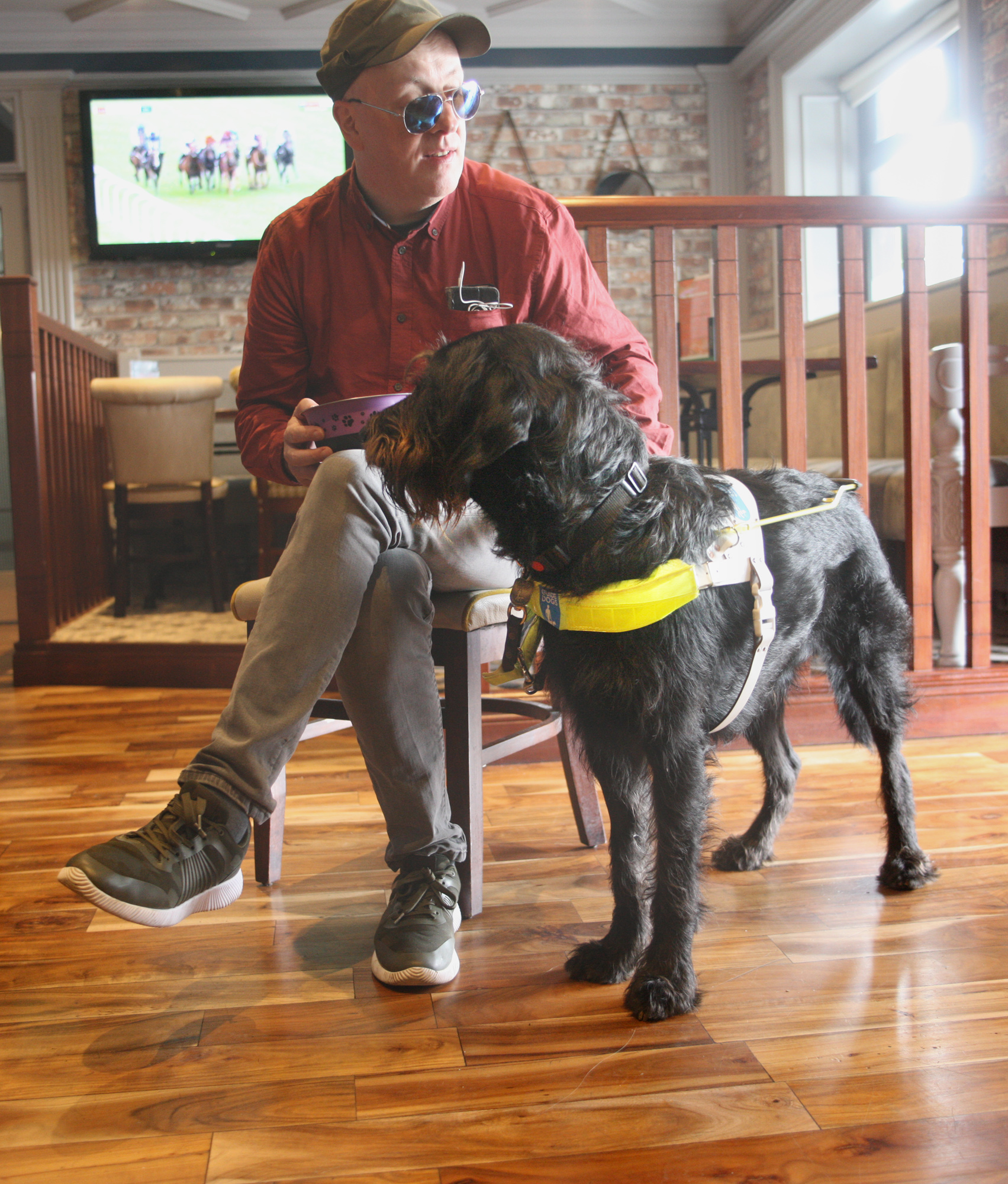 TEAM: The Balmoral Hotel’s Colm Glover with his guide dog Obi in the Greenan Bar