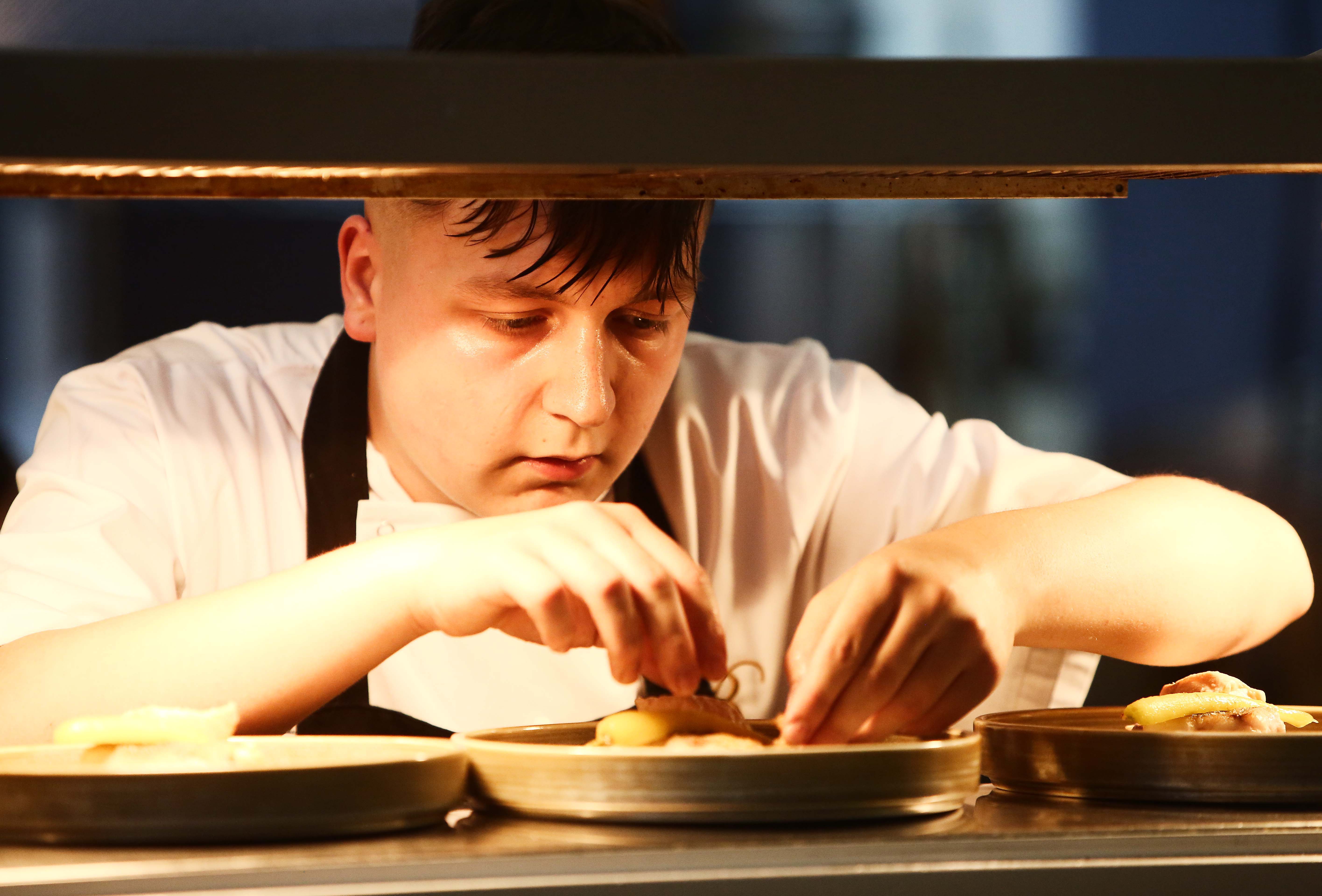 Young chef Harry Barkley puts the finishing touches to his dish of salmon and cod at the pass in the Balmoral Hotel kitchen. Harry scored a double triumph on the night, scooping the People\'s Choice award (voted for by the audience who sampled a taster of the food of all four finalists) and he was declared the overall winner by a panel of four distinguished judges. Harry weaves his culinary magic at Brothers restaurant in Ballyclare.