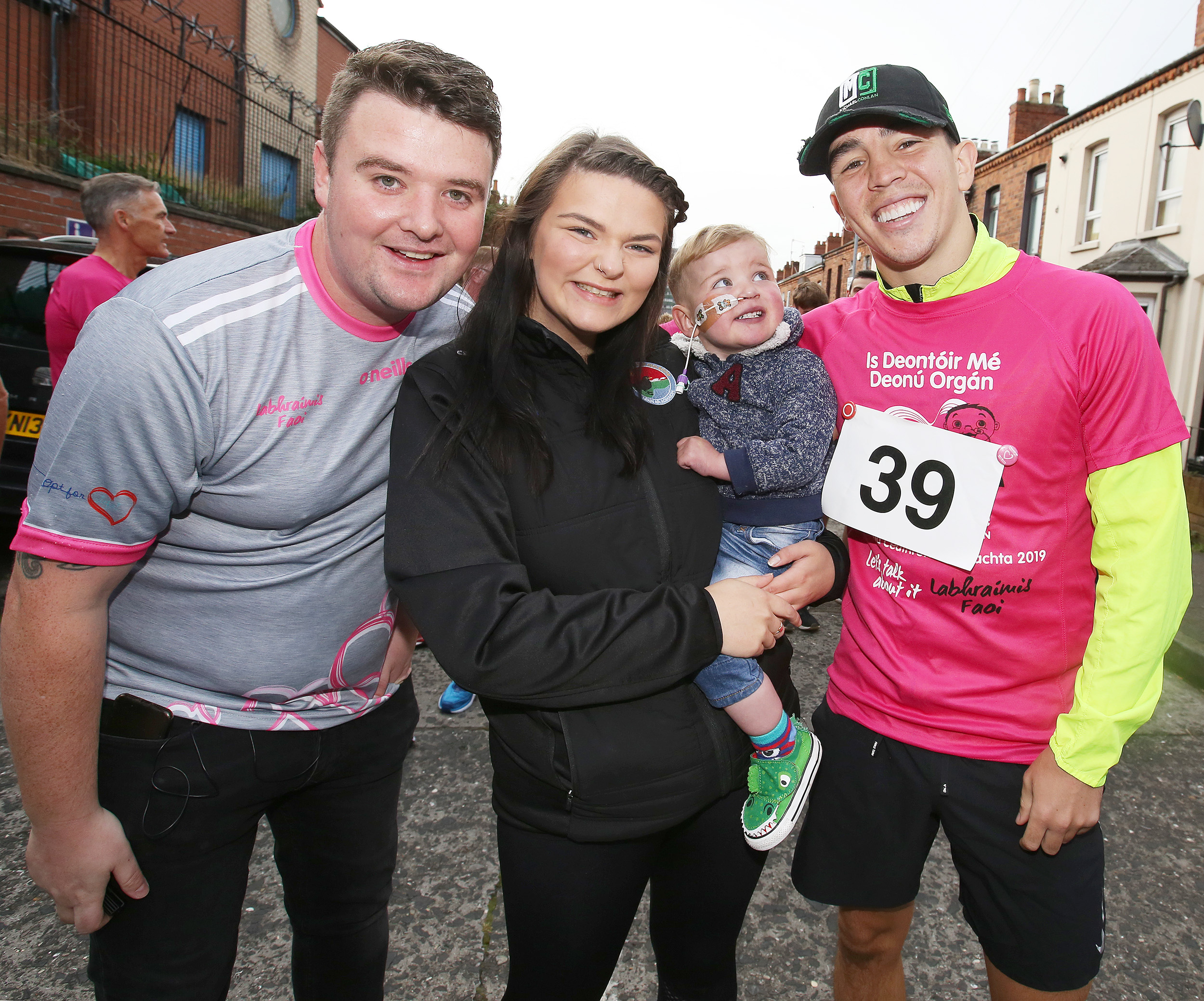 WBA/WBO Inter-Continental Featherweight Champion Michael Conlan laces up with Máirtín and Seph, parents of West Belfast toddler Dáithí Mac Gabhann, to show his support for the Gaeltacht Quarter 10K as part of Organ Donation Week