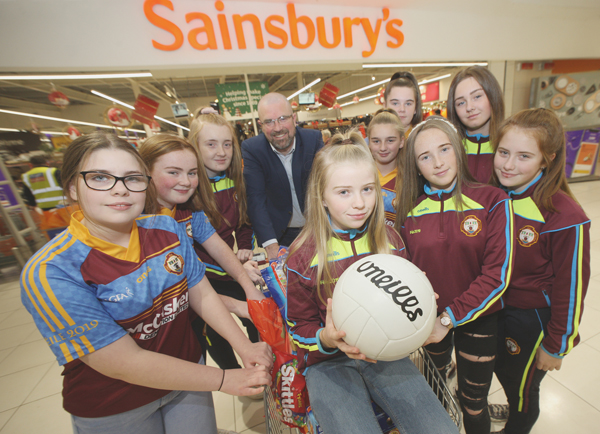 Kennedy Centre Manager John Jones donates some goodies to Gort na Móna girls footballers for their Christmas party