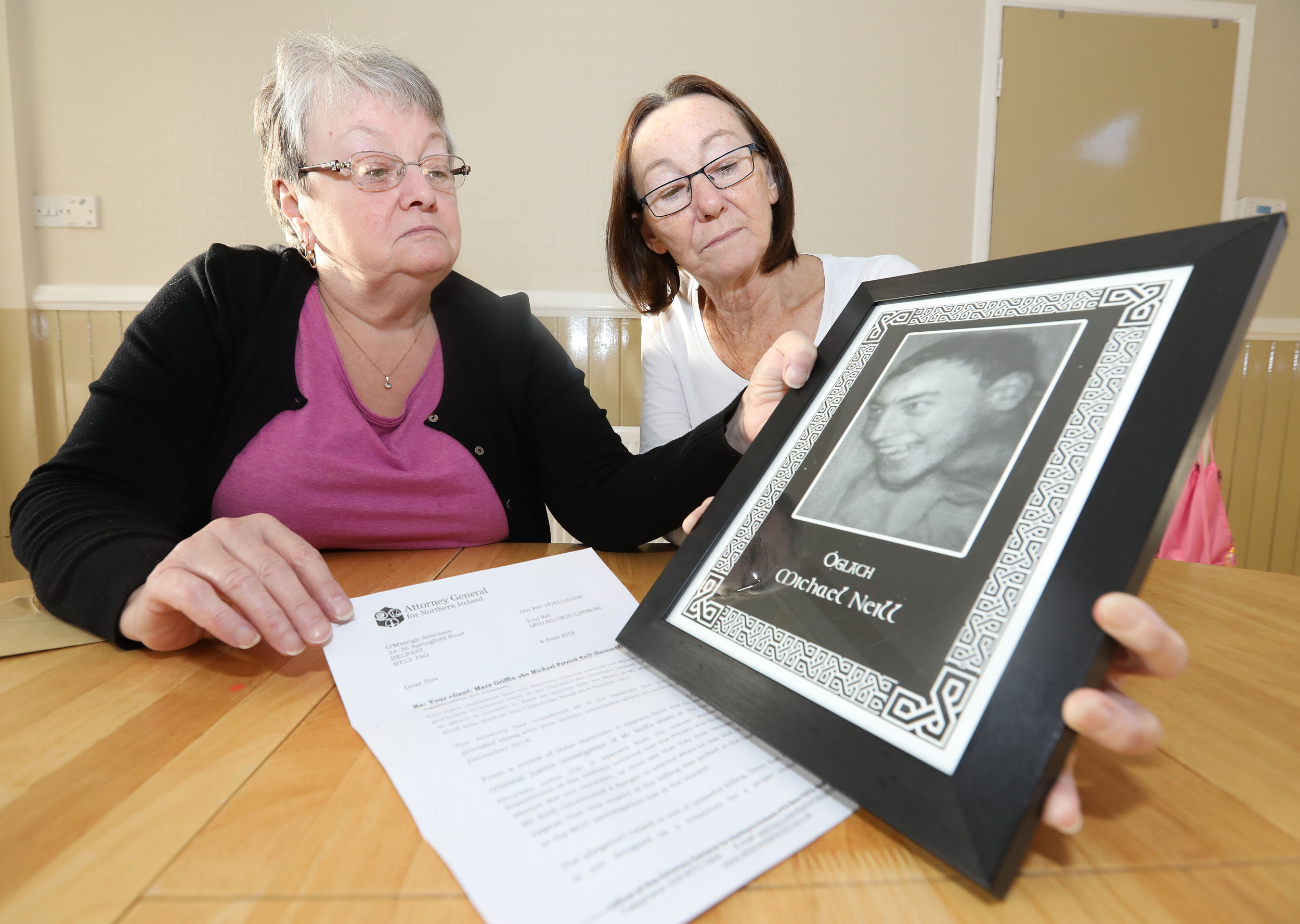 JUSTICE: Maureen Griffin and Patricia Friel with a treasured portrait of their brother Michael Neill