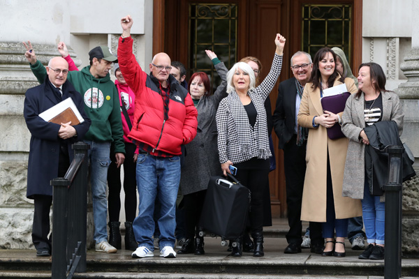 Margaret McGuckin SAVIA (Survivors and Victims of Institutional Abuse) and survivors raise their hands in victory outside the High Court In Belfast
