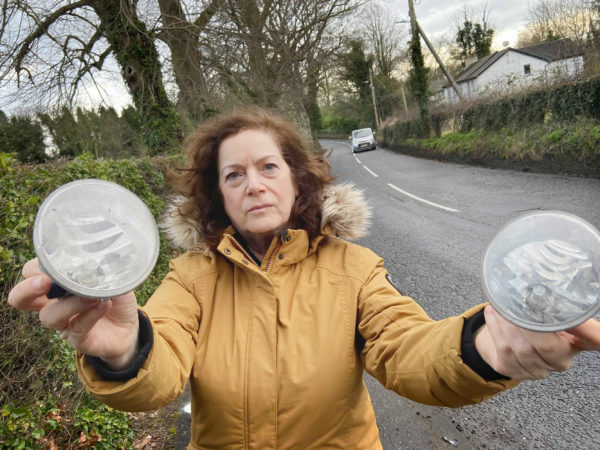 BLACKSPOT: Cllr Geraldine McAteer holding lights from cars that have had accidents at the bend in Dunmurry