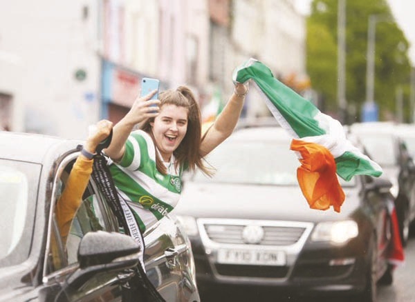 A Celtic fan celebrates during a calvalcade along the Falls Road on Monday evening