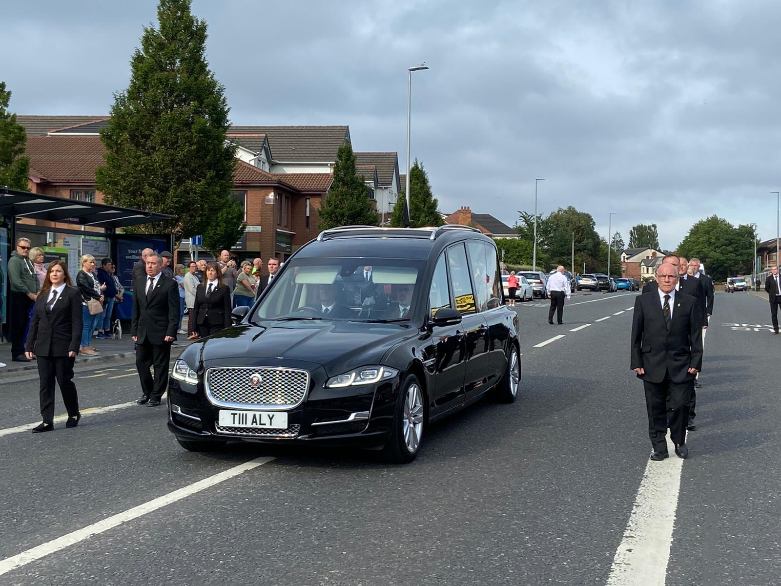 COMRADES: The hearse carrying Bobby Storey\'s remains is escorted to his home by a colour party. 