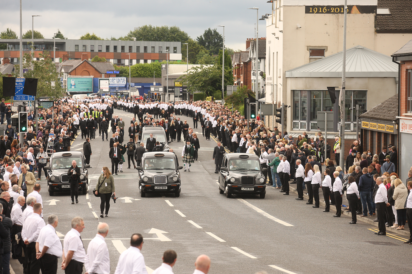 FINAL JOURNEY: Bobby Storey\'s funeral cortege makes its way past Felons Club in Andersonstown